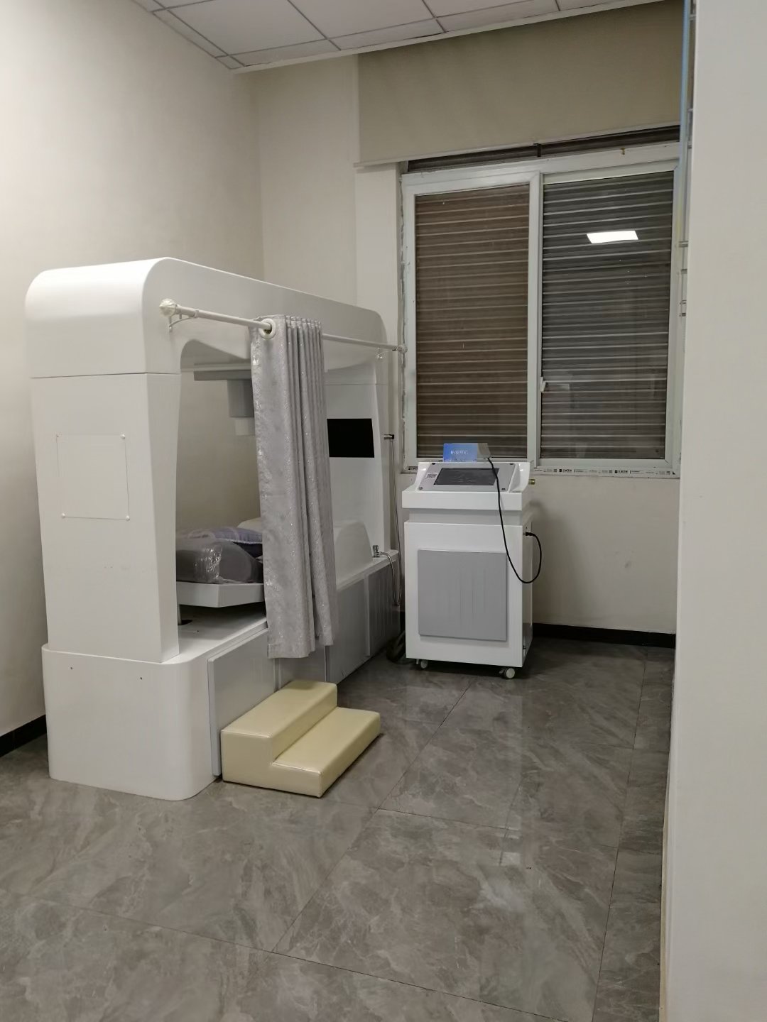 Happy clinic owner with MAIKONG colonic machine in professional setting